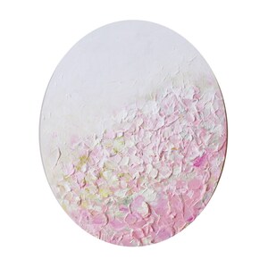 May include: A round canvas painting with a textured, abstract design. The background is white, and the foreground is a gradient of pink and white.