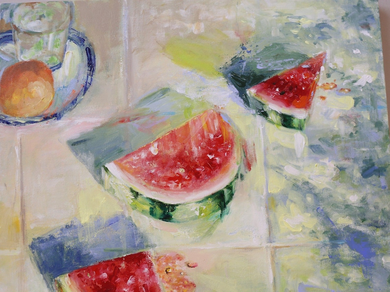 May include: An oil painting depicting three slices of bright red watermelon with green rinds, arranged on a light-coloured tiled surface. A small plate holding a glass of water and a round orange fruit is visible in the upper left corner.