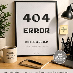 May include: A black framed print with the text "404 ERROR COFFEE REQUIRED". A coffee mug with the text "COFFEE. DEADLINES. SURVIVE." sits next to a notepad and pen. A black desk lamp and a sticky note that says "DON'T OVERTHINK IT" are also visible.