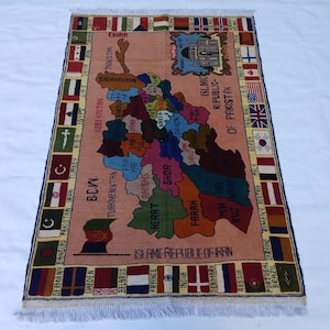 May include: A rectangular rug with a map design, showcasing countries and regions in various colours. The rug includes flags and text, with a central map of the Middle East and surrounding areas. The rug has a cream background and a fringed edge.