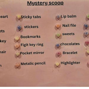 May include: A pink poster with the words "Mystery scoop" and a list of items, including sticky notes, stickers, keychains, hair clips, erasers, lip balm, nail files, sweets, chocolates, bracelets, highlighters, and squishy toys.