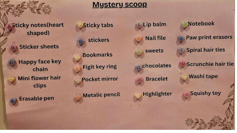 May include: A pink poster with the words "Mystery scoop" and a list of items, including sticky notes, stickers, keychains, hair clips, erasers, lip balm, nail files, sweets, chocolates, bracelets, highlighters, and squishy toys.
