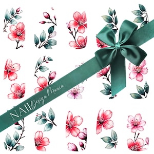 Puede incluir: Calcomanías de arte de uñas con diseños de flores de cerezo en acuarela en tonos rosa y rojo, con hojas y tallos verdes. Una cinta verde azulado con un lazo cruza la imagen en diagonal, con el texto "NAIL Design Mania".