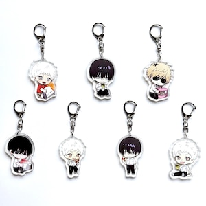 May include: Seven anime-style character keyrings are displayed. Each keyring showcases a unique character design with diverse hair colours and outfits. The keyrings are made of clear acrylic and have silver-coloured key rings.