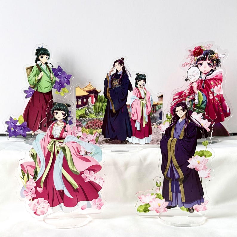 Puede incluir: Soportes acr&iacute;licos con personajes de estilo anime con vestimenta asi&aacute;tica tradicional. Las figuras est&aacute;n en varias poses, con ropa detallada y detalles florales. La paleta de colores incluye tonos de rosa, morado, verde y negro.