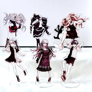 Może przedstawiać: Kolekcja akrylowych figurek postaci z anime. Figurki przedstawiają różne postacie w szczegółowych strojach, z mieszanką czerni, bieli i czerwieni. Każda figurka ma przezroczystą podstawę do ekspozycji.