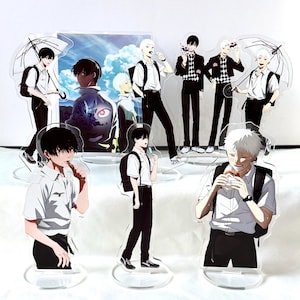 Könnte beinhalten: Acryl-Anime-Charakter-Standees mit verschiedenen männlichen Figuren in Schuluniformen. Die Figuren haben schwarze und weiße Haare und werden in verschiedenen Posen dargestellt. Einige halten Regenschirme oder essen. Der Hintergrund zeigt eine Landschaft mit blauem Himmel.