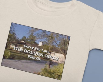 May include: A white t-shirt with a graphic of the exterior of a house with the text "Sorry I'm Late The Golden Girls Was On".