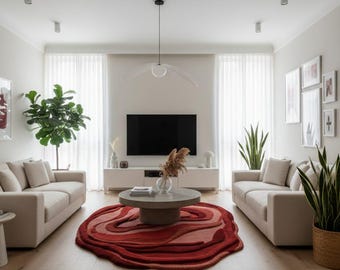 May include: A modern living room with neutral-toned sofas, a round coffee table, and a vibrant red and pink patterned rug. The room features a large black television, plants, and a decorative light fixture, creating a stylish and inviting space.