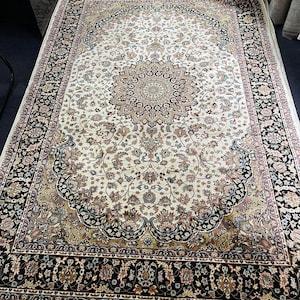 Neutral ivory and black modern rug displayed on wooden flooring to show contrast and décor styling.