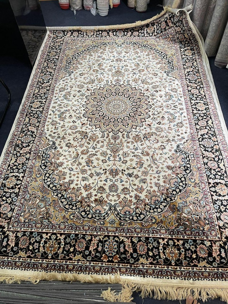 Neutral ivory and black modern rug displayed on wooden flooring to show contrast and décor styling.