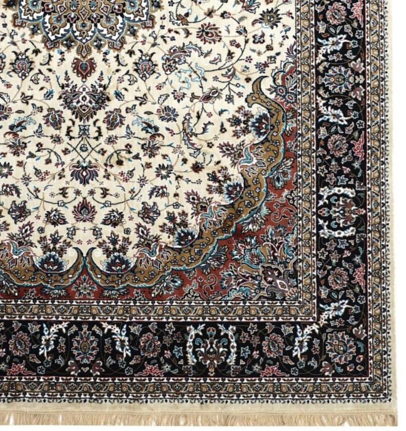 May include: Ivory-colored area rug with an intricate floral pattern in shades of brown, red, and blue. The rug features a detailed border in black and ivory, with a fringe along the bottom edge. A classic home decor item.
