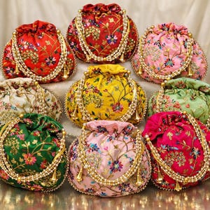 May include: A collection of nine embroidered drawstring pouches in various colors, including red, pink, green, and yellow. Each pouch features floral patterns, beaded accents, and a drawstring closure. The pouches are arranged in a circular pattern.