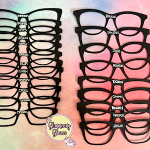 Könnte beinhalten: Schwarze Brillen-Ausschnitte mit Namen in weißer Schrift. Die Brillen sind in zwei Gruppen gestapelt. Zu den Namen gehören Wanda, Otto, Reese, Ella, Kirby, Twain und andere. Ein Logo mit dem Text "Glimmering Glasses" befindet sich unten rechts.