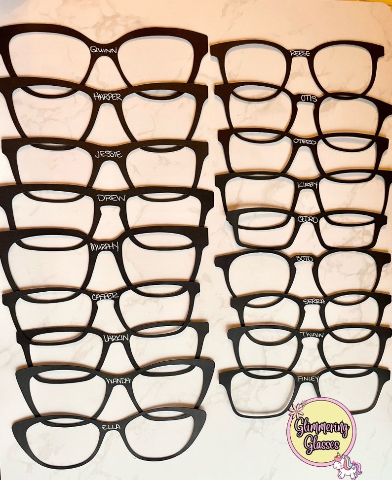 Puede incluir: Gafas recortadas en blanco y negro con nombres escritos en blanco en cada par. Los nombres son Quinn, Reese, Harper, Otis, Jessie, Drew, Murphy, Casper, Larkin, Wanda, Ella, Otero, Kirby, Cedro, Serra, Twain, Finley y Soto. Las gafas est&aacute;n dispuestas en dos columnas, con la parte superior de cada columna comenzando con el nombre Quinn y Reese. La parte inferior de cada columna termina con el nombre Ella y Soto. El texto "Glammering Glasses" est&aacute; escrito en rosa y blanco con un gr&aacute;fico de unicornio debajo.