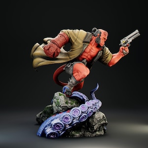 Op de afbeelding: Een rode Hellboy-figuur met een beige trenchcoat en een pistool. De figuur is dynamisch geposeerd, staand op een rots met een blauwe en paarse tentakel. De figuur heeft een gespierd lichaam en een staart.
