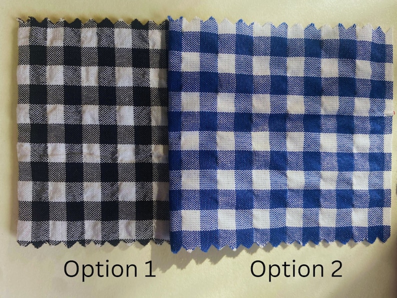 Op de afbeelding: Twee stofstalen met een ruitjespatroon. De staal links is zwart-wit. De staal rechts is blauw-wit. De stalen zijn gelabeld met "Optie 1" en "Optie 2".