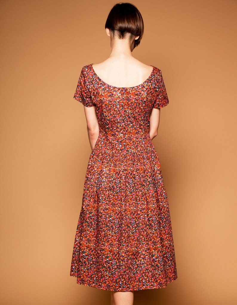 May include: A red, orange, and blue floral print midi dress with short sleeves and a scoop neckline.