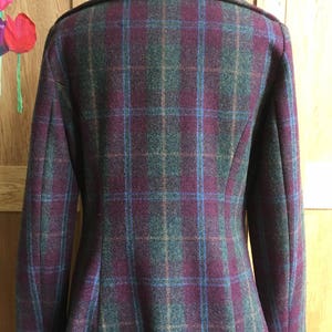 May include: A burgundy, green, and blue plaid coat with a collar and long sleeves.
