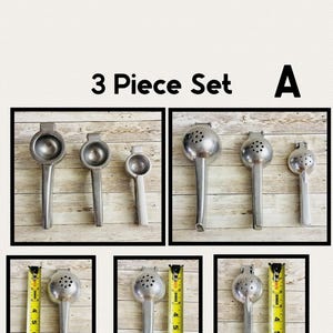May include: A set of three vintage metal citrus juicers. The juicers are silver-toned with long handles and various head designs. The image includes the text "3 Piece Set A".