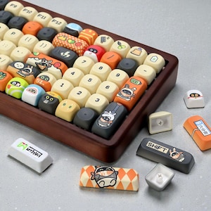 May include: A custom keyboard with a wooden frame and a variety of colorful keycaps. The keycaps feature unique designs, including cartoon characters, patterns, and the text "SHIFT" and "六分街". The keyboard is displayed on a light gray surface.