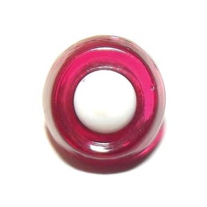 May include: A circular, translucent magenta glass bead with a smooth, polished surface and a large, centered hole. The bead features a vibrant, deep pink hue that catches the light, creating a glossy appearance with a clear, open center.