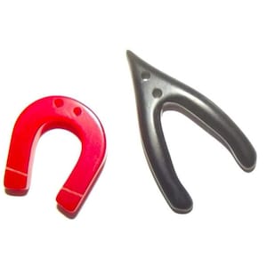 Puede incluir: Dos imanes sobre un fondo blanco. Uno es rojo brillante en forma de herradura, y el otro es negro en forma de horquilla. Ambos imanes tienen pequeños agujeros.