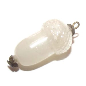 May include: A clear glass acorn-shaped pendant featuring a textured cap with a grid-like pattern. The piece includes a metallic loop at the top for suspension and a small decorative metal cap at the bottom, providing a finished look to the design.