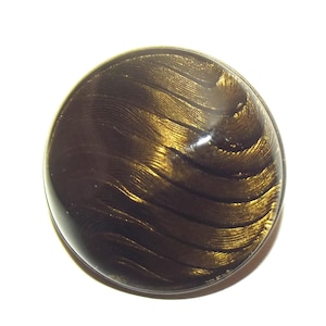 May include: A circular, dark brown button with a shiny surface. The button has a swirling, textured design in gold, producing a distinctive visual impact. The button is suitable for clothing or craft projects.