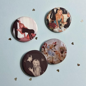May include: Four circular pin-back buttons featuring photographic prints of a blonde person in various settings. One shows a person kneeling in a black dress, another a person at a dinner table, one in a floral chair, and one in a dark portrait.