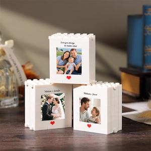 May include: Three white building block cubes featuring custom photo prints on the front. The top cube shows a family with the text "Love you always, no matter what". The bottom left shows a wedding couple, and the bottom right shows a parent and child.