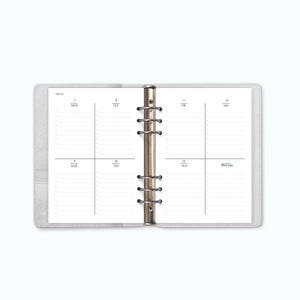 Peut inclure: Agenda hebdomadaire ouvert, avec une couverture grise. Les pages blanches sont quadrillées de lignes noires et de texte pour les jours de la semaine. L'agenda est ouvert sur une double page avec les jours de la semaine, du lundi au samedi. Reliure argentée.