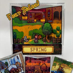 Könnte beinhalten: Eine transparente Acryl-Vitrine mit einem Diorama einer Videospielszene, mit dem Text "Four Sides!" in gelber Schrift. Die Hauptanzeige zeigt eine Frühlingsszene, mit kleineren Anzeigen für Winter, Herbst und Sommer.