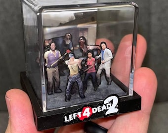 Może przedstawiać: Miniaturowa diorama z postaciami z gry Left 4 Dead 2, zamknięta w przezroczystej akrylowej kostce. Czarna podstawa z logo gry. Figurki są szczegółowe i ustawione w dynamicznych pozach.