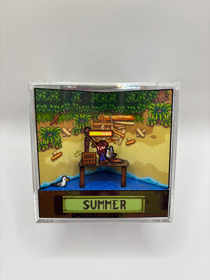 May include: A pixelated diorama featuring a fishing scene with a figure on a wooden dock. The scene includes a seagull, sand, water, and lush greenery. The word "SUMMER" is displayed on a green banner at the bottom.