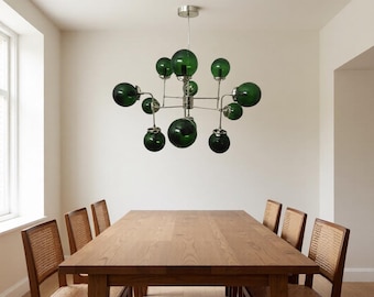 幾何学的なアームと複数の球体を備えた現代的なグリーンガラスとゴールドのシャンデリア