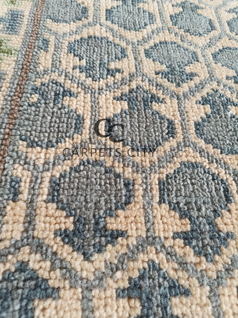 Handmade wool runner rug featuring a geometric lattice design in soft beige, blue, and green tones with tribal border details. This long hallway rug adds timeless style to entryways, kitchens, or bedside décor. Durable handwoven construction with fringe edges enhances farmhouse, boho, and modern interiors. Neutral yet colorful design makes it versatile for layering or as a statement runner. Perfect handmade rug for hallways, narrow spaces, and unique home décor accents.