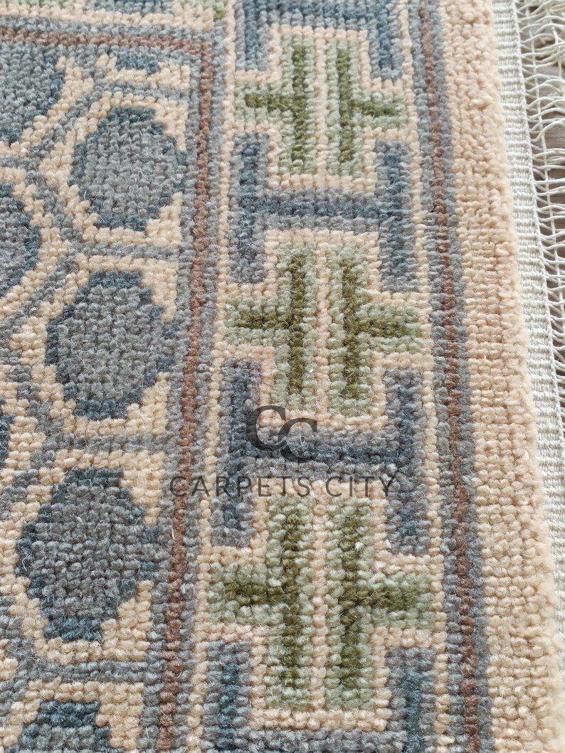 Handmade wool runner rug featuring a geometric lattice design in soft beige, blue, and green tones with tribal border details. This long hallway rug adds timeless style to entryways, kitchens, or bedside décor. Durable handwoven construction with fringe edges enhances farmhouse, boho, and modern interiors. Neutral yet colorful design makes it versatile for layering or as a statement runner. Perfect handmade rug for hallways, narrow spaces, and unique home décor accents.