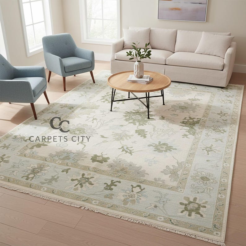 May include: A large, rectangular area rug with a floral pattern in shades of green and beige. The rug has a border with a lighter green hue and fringe along the edges. The text "CARPETS CITY" is visible on the rug.