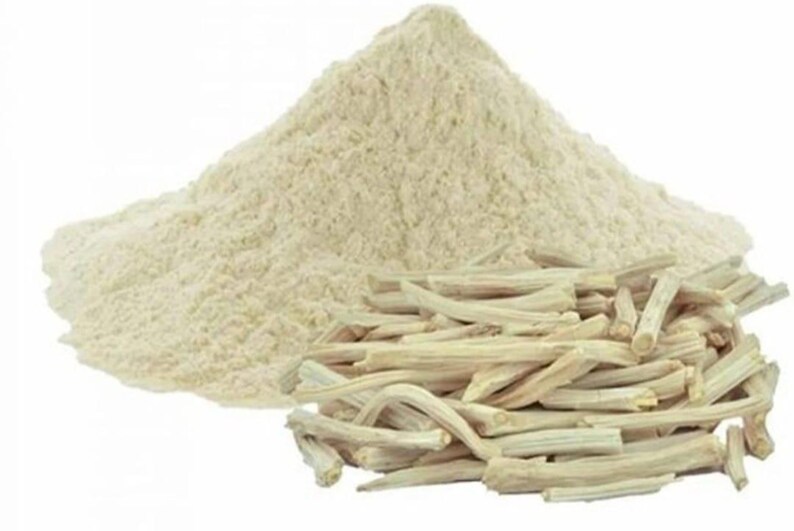 K&ouml;nnte beinhalten: Ein Haufen hellbeige Pulver neben einer Ansammlung von hellbraunen, getrockneten, st&auml;bchenartigen St&uuml;cken. Das Pulver ist fein gemahlen, und die St&auml;bchen haben eine raue Textur. Auf wei&szlig;em Hintergrund.