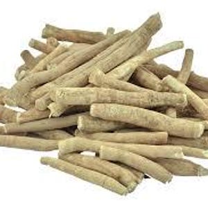 May include: A pile of ashwagandha roots, showcasing a light tan color and a rough, textured surface. The roots vary in size and shape, with some appearing thicker and others more slender. The background is plain white, highlighting the natural appearance of the roots.