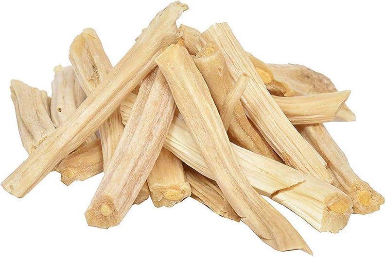 May include: A pile of light brown Palo Santo wood sticks. The sticks are rectangular with a natural, textured appearance. The ends of the sticks are cut, revealing the wood's grain. The wood has a light, natural color.