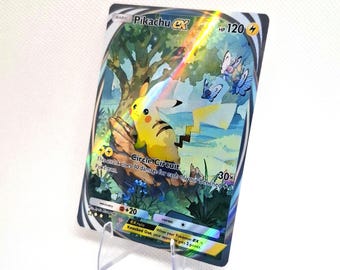 May include: A Pikachu ex trading card featuring a yellow electric-type character sitting on a tree branch with blue butterflies in a forest setting. The card displays 120 HP, the Circle Circuit attack, and holographic light reflections across the surface.