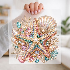 May include: A square clear acrylic panel featuring a vibrant diamond art design of a central starfish surrounded by various seashells, coral branches, and colourful faceted gems in shades of pink, blue, gold, and iridescent white.