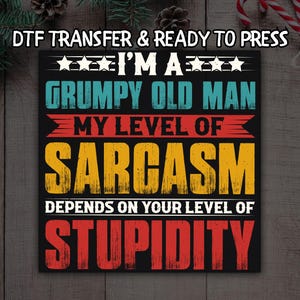 May include: Black square with the text "I'M A GRUMPY OLD MAN MY LEVEL OF SARCASM DEPENDS ON YOUR LEVEL OF STUPIDITY" in various colors. The words "DTF TRANSFER & READY TO PRESS" are at the top.