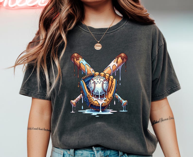 May include: Dark gray t-shirt featuring a baseball design. The graphic shows a baseball, bat, and glove with a melting ice cream effect. The baseball is white with red stitching. The bat is brown with dripping chocolate. The glove is yellow and blue.