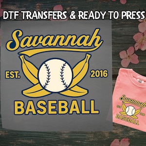 May include: A grey DTF transfer featuring the text "Savannah Baseball" and a baseball graphic with bananas. A pink t-shirt with the same design is on the right. The text "DTF TRANSFERS & READY TO PRESS" is at the top.