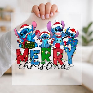 May include: A clear sheet featuring a graphic of four blue Stitch characters wearing red and white Santa hats. The characters are surrounded by colorful Christmas lights. The text MERRY CHRISTMAS is printed in large, bold, multi-colored letters.