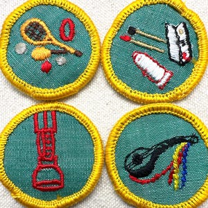 May include: Four embroidered patches with a teal background and yellow border. Each patch features a different design: a tennis racket, paintbrushes and palette, a stirrup, and a stringed instrument. The patches are likely for a youth organization.