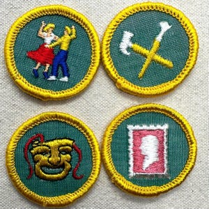 May include: Four embroidered patches with yellow trim. The patches feature images of a dancing couple, crossed tools, a theater mask, and a profile portrait. The patches are circular with a green background.
